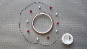 Tout le matériel nécessaire pour faire un tambourin: un cadre à broderie, des grelots et un cordon en coton