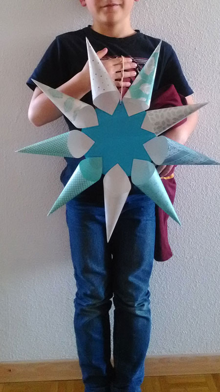 Un petit garçon qui l'étoile qu'il a réalisée et qui pose fièrement devant l'objectif :)